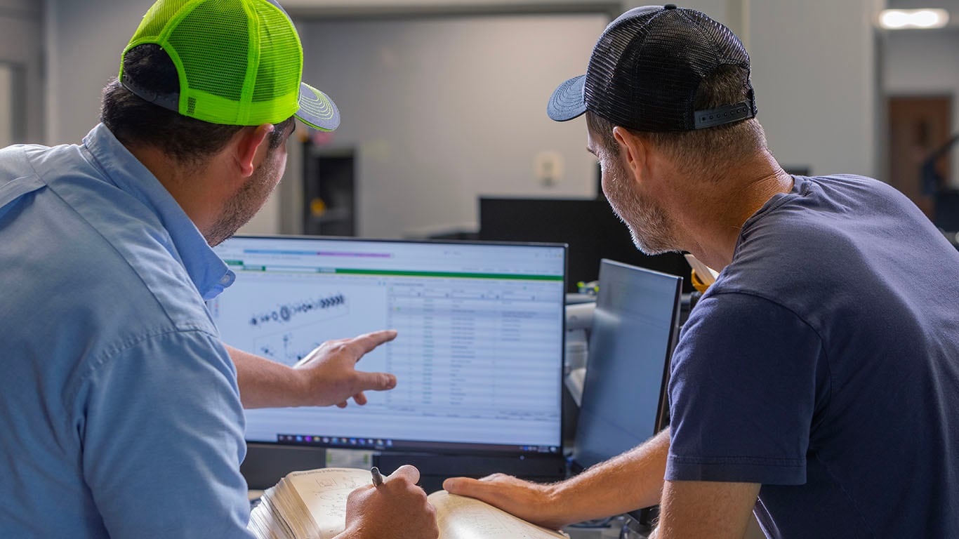 Two Men looking at a computer screen.