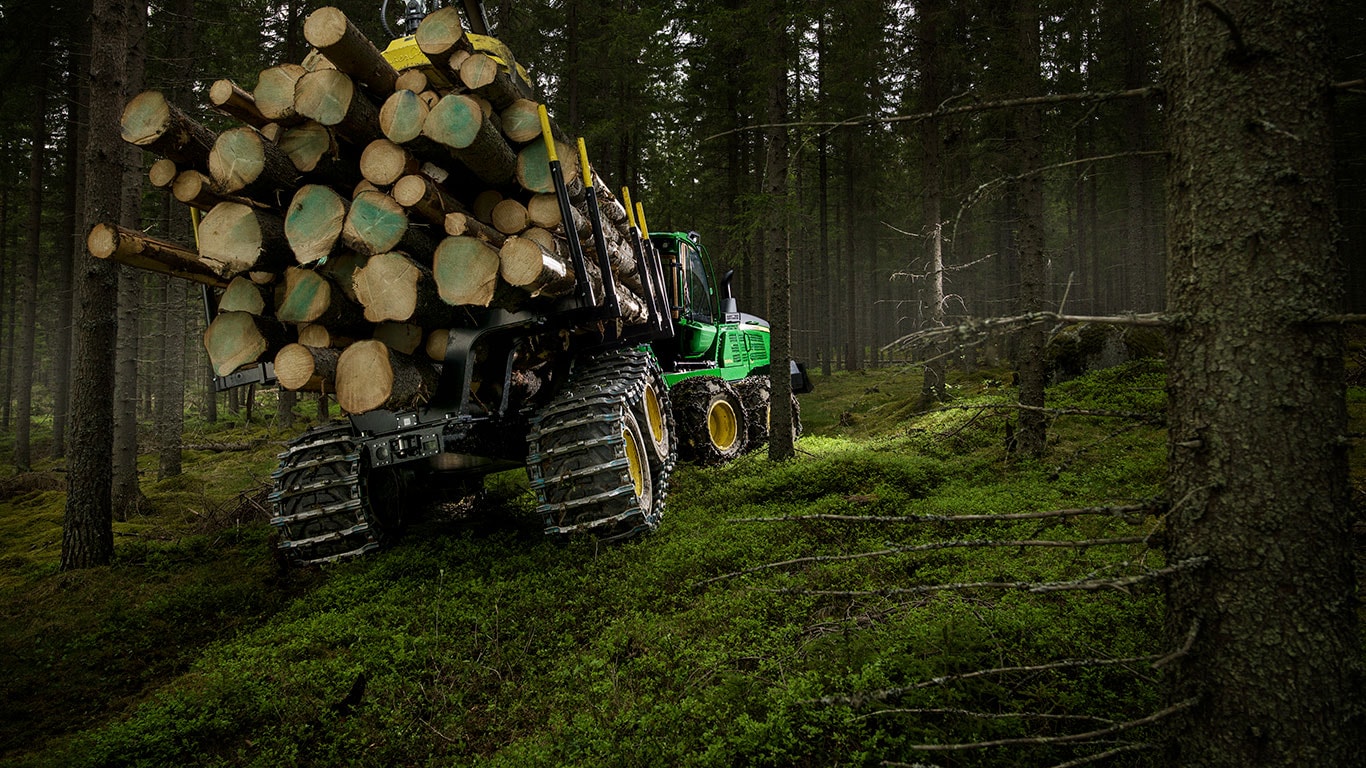 John Deere 1510G forwarder is carrying logs in the forest