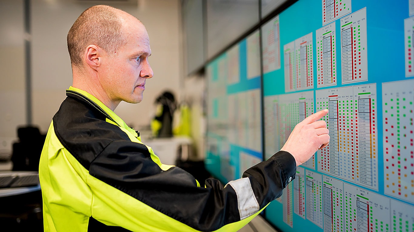 A man and graphs with green and red squares on the wall