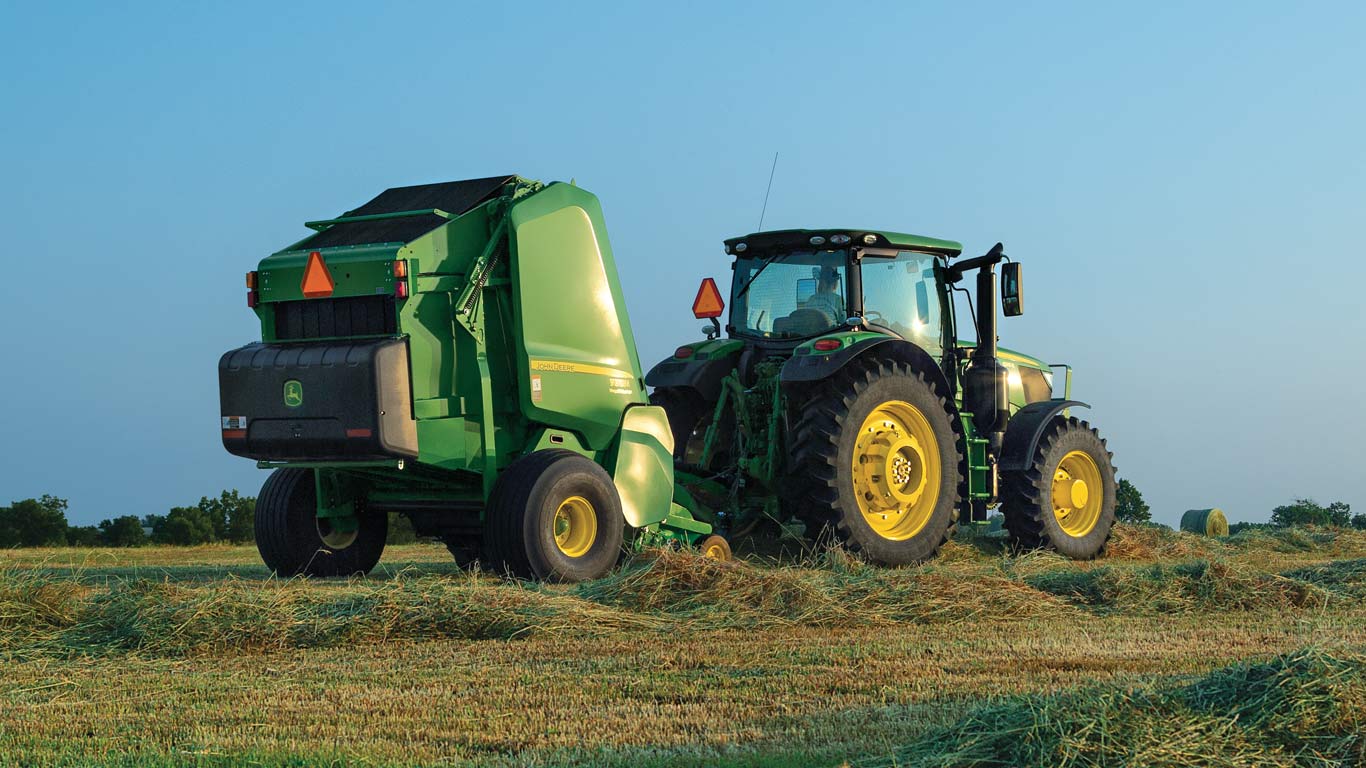 image of round baler hooked to tractor in a field