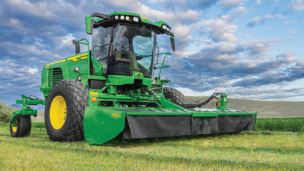 Windrower in a field under blue sky
