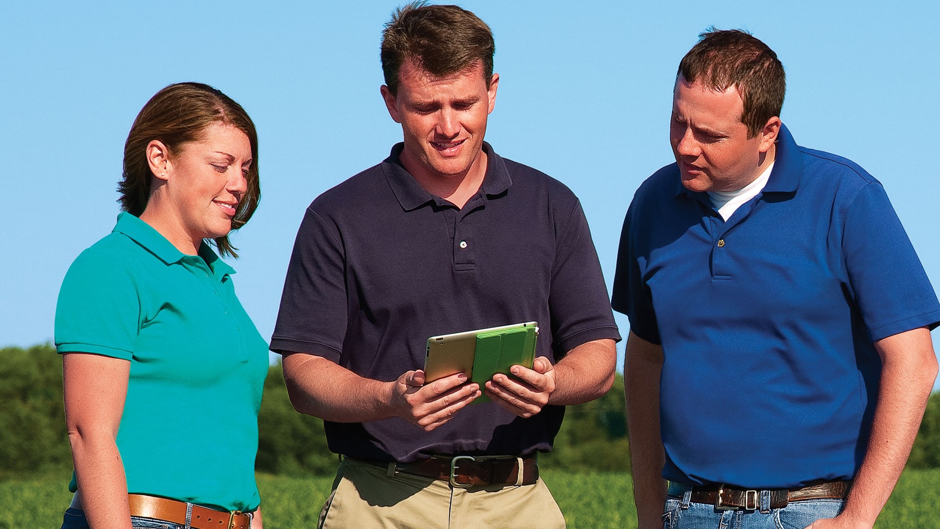 Group standing in field with mobile device